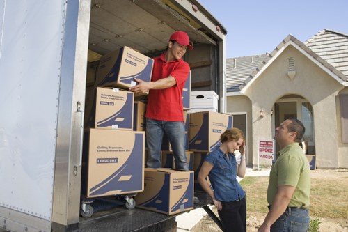 Commercial moving crew loading office furniture into a truck in a busy district